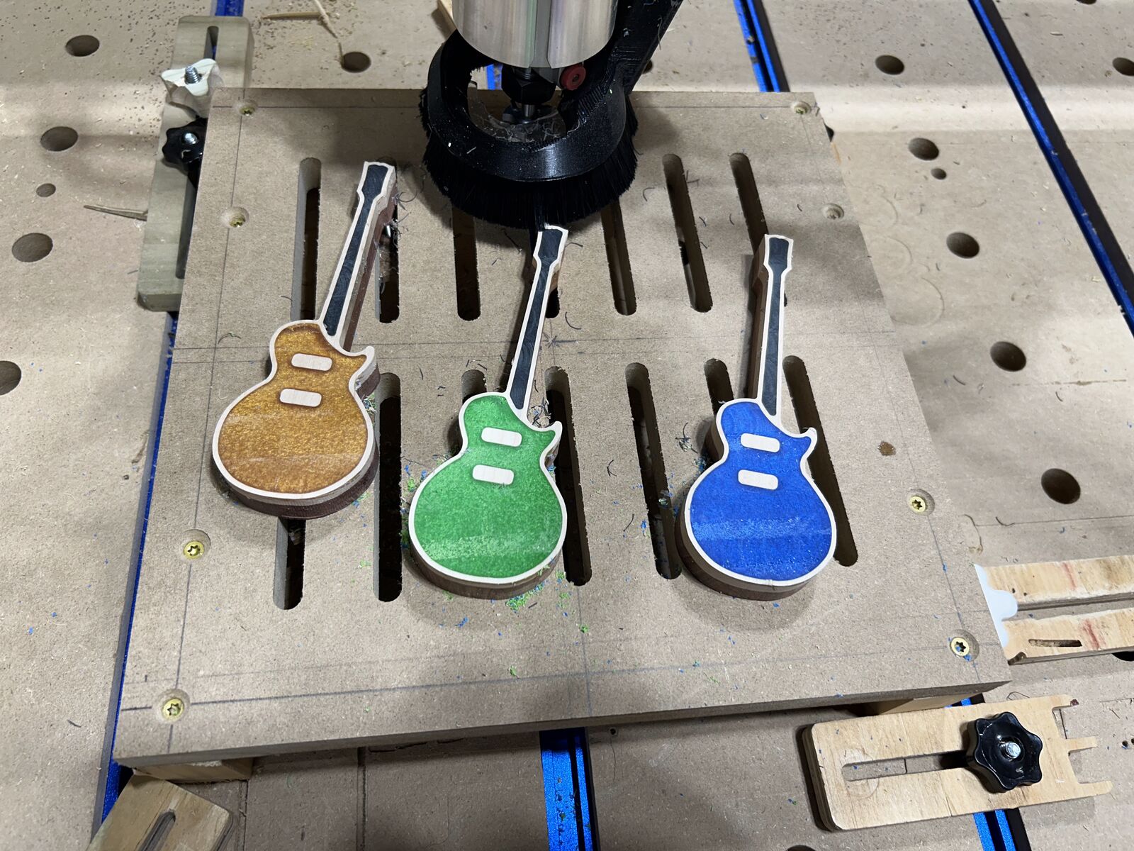 Painted guitar-shaped drawer pulls on the CNC spoilboard