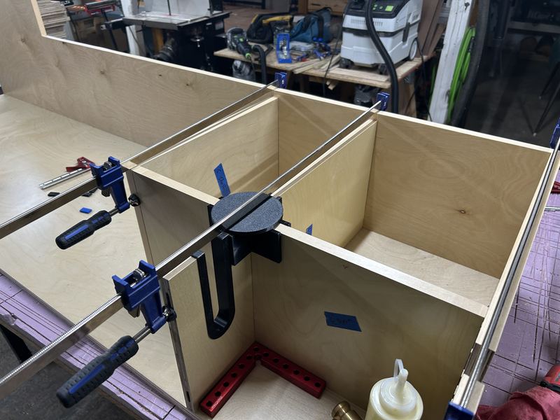 Locker shelves and dividers glued up with clamps and a 3D-printed squaring jig