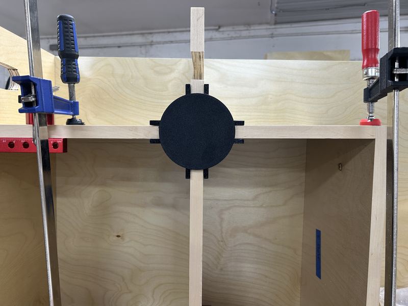 3D-printed jig clamped at a divider joint in an assembled locker