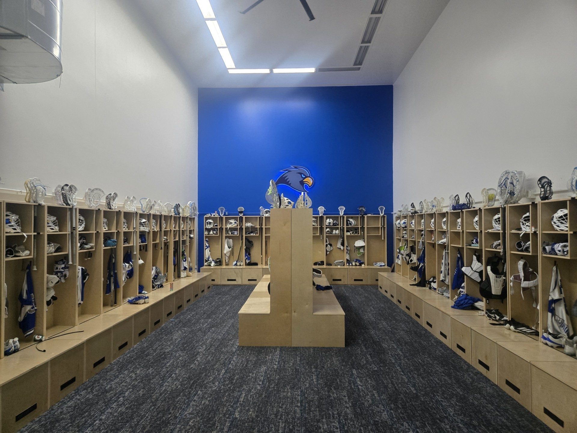 The finished Rockhurst University lacrosse locker room with lockers on three walls and center benches