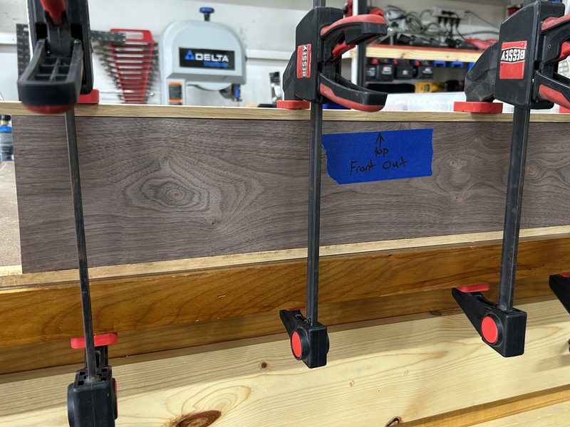Walnut panel for a coffee table glued up in bar clamps